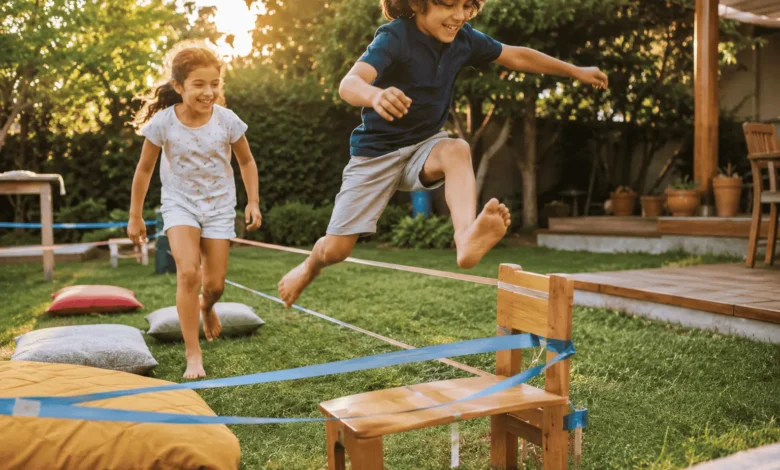 Two children aged 5–9 laughing and playing on a homemade backyard obstacle course, with tape lines and cushions on the grass in warm golden afternoon sunlight, promoting active outdoor play and family fun