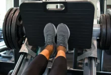 Feet positioned low and narrow on a leg press machine for a quad-focused leg press