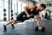 Person performing a renegade row in a plank position with a dumbbell pulled toward the ribcage
